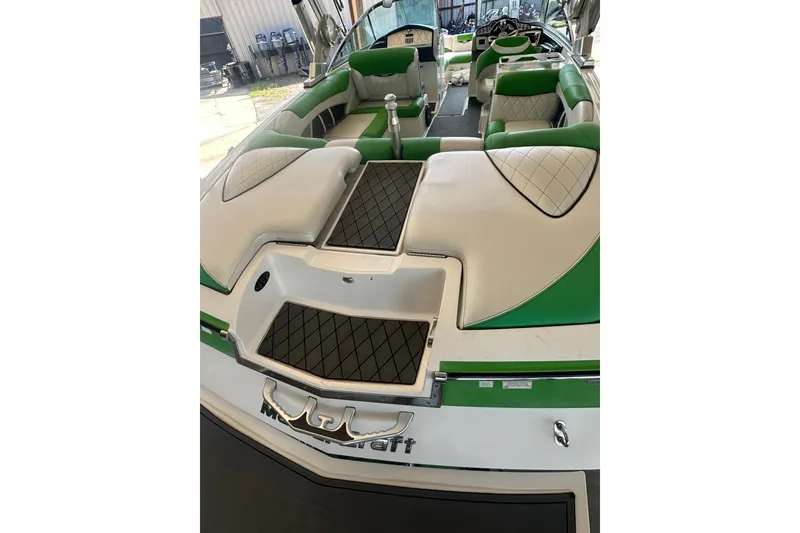 Slide: The Image of 2013 MasterCraft X55 boat interior with green and white seating. - 10