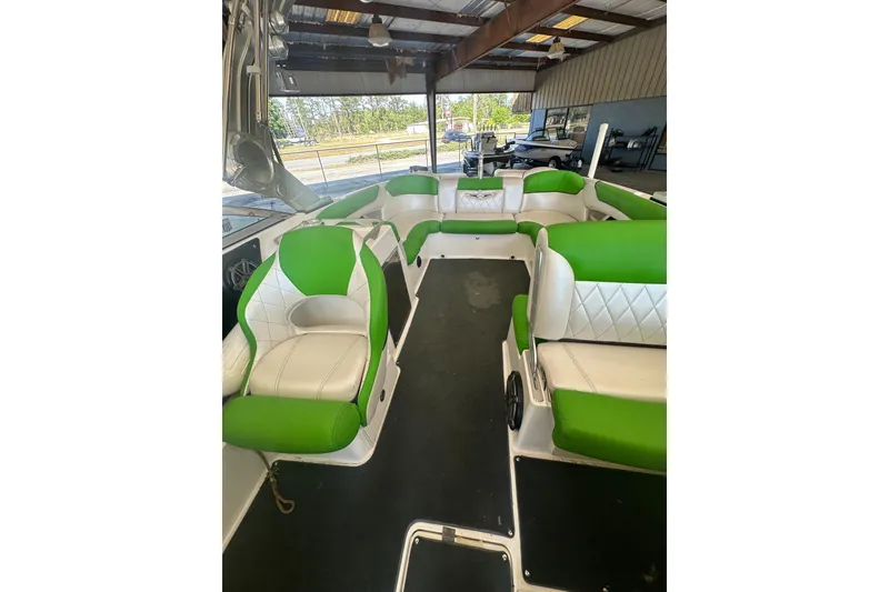 Slide: The Image of 2013 MasterCraft X55 boat interior with green and white seating under a covered area. - 4