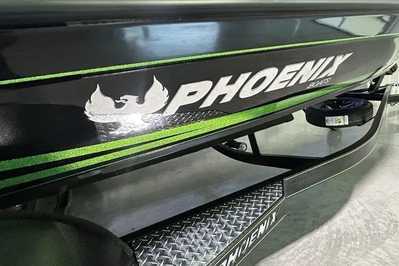 Slide: The Image of 2026 Phoenix 819 ZXL boat with green accents and logo on trailer. - 2
