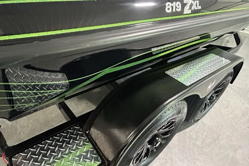 Slide: The Image of 2026 Phoenix 819 ZXL boat trailer with green accents and diamond plate steps. - 3