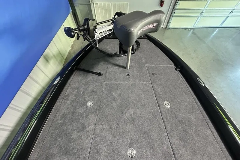 Slide: The Image of 2026 Phoenix 819 ZXL boat deck with seat and trolling motor in a garage. - 8
