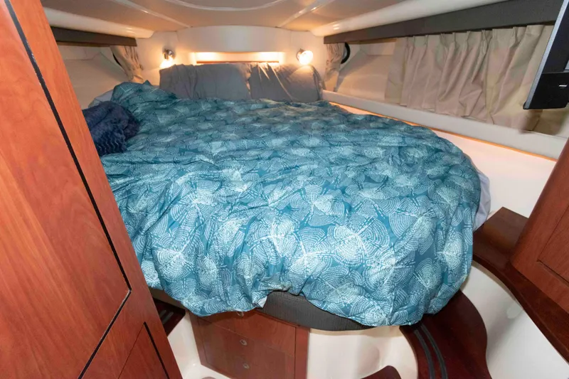 Slide: The Image of Cozy cabin interior of 2008 Monterey 350 Sport Yacht with a patterned blue bedspread. - 16
