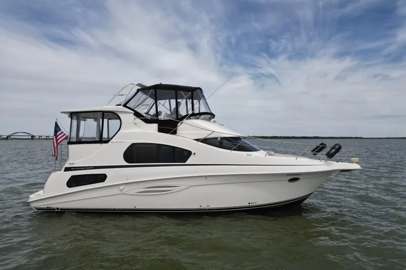 The Image of 2003 Silverton 39 Motor Yacht on calm water under a partly cloudy sky. - 1