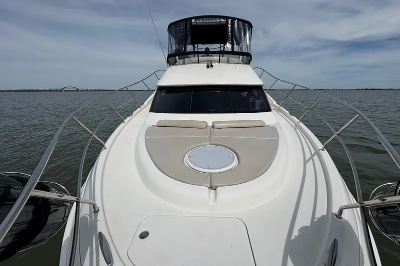 Slide: The Image of 2003 Silverton 39 Motor Yacht on calm water, showcasing sleek design and spacious deck. - 13