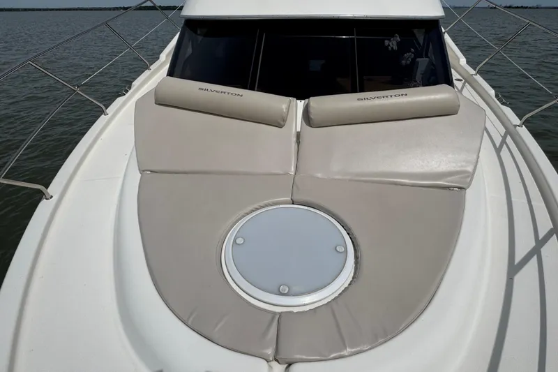 Slide: The Image of 2003 Silverton 39 Motor Yacht deck with cushioned seating and circular hatch. - 15