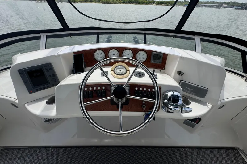 Slide: The Image of 2003 Silverton 39 Motor Yacht helm with steering wheel, gauges, and navigation controls. - 20