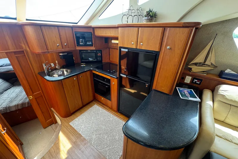 Slide: The Image of Interior of 2003 Silverton 39 Motor Yacht with wood cabinetry and modern kitchen amenities. - 24