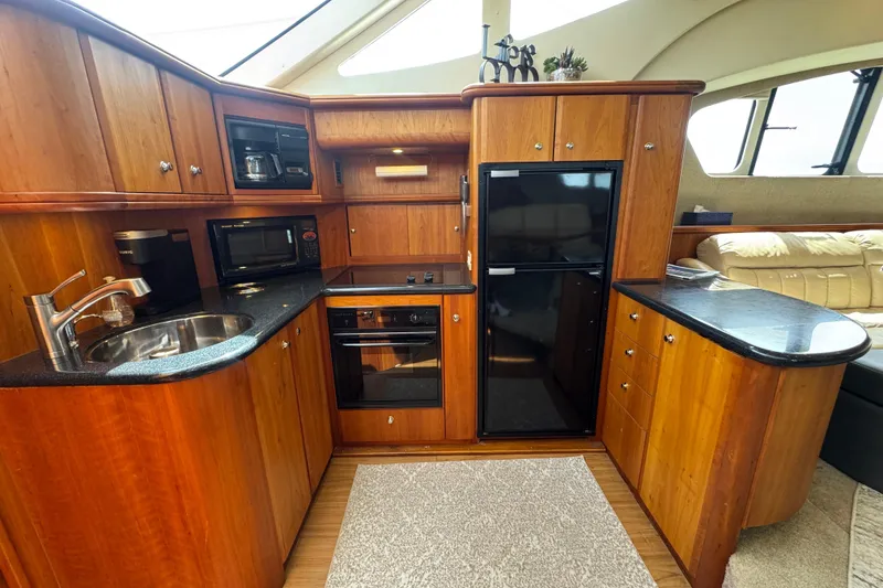 Slide: The Image of Luxurious kitchen interior of 2003 Silverton 39 Motor Yacht with wood cabinetry and modern appliances. - 25