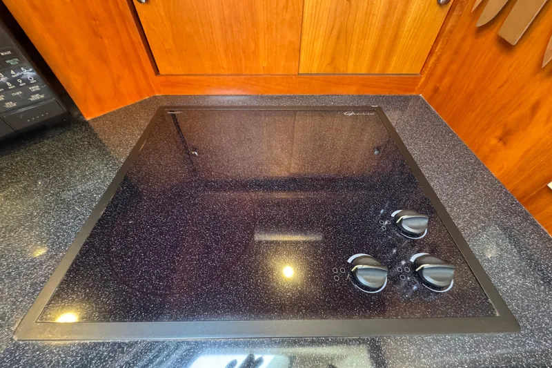 Slide: The Image of Stovetop in 2003 Silverton 39 Motor Yacht kitchen with wooden cabinetry. - 26