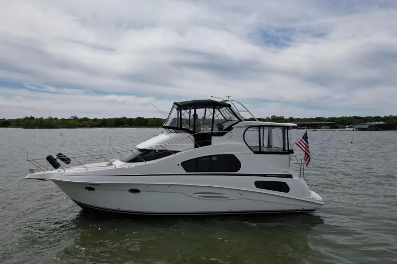 Slide: The Image of 2003 Silverton 39 Motor Yacht on calm water with American flag. - 3