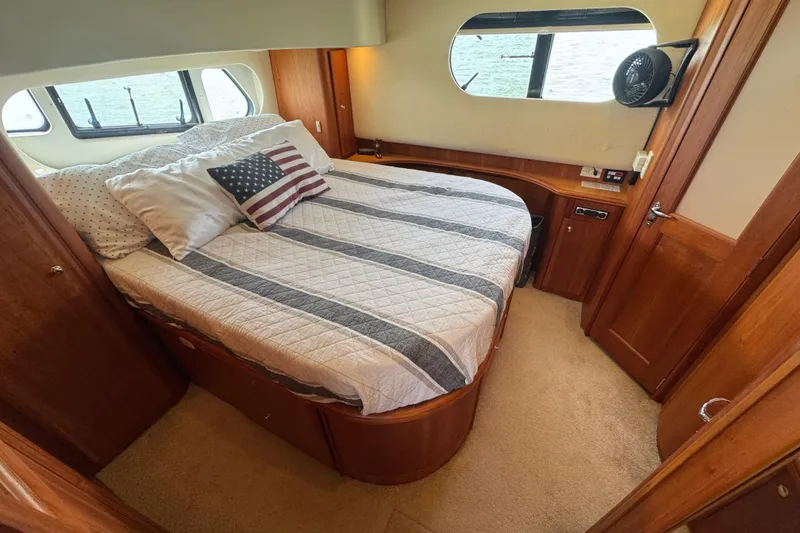 Slide: The Image of Cozy bedroom in 2003 Silverton 39 Motor Yacht with striped bedding and American flag pillow. - 30