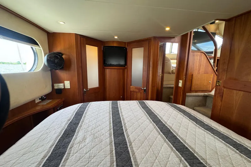 Slide: The Image of Interior of 2003 Silverton 39 Motor Yacht with cozy bedroom and wooden accents. - 31