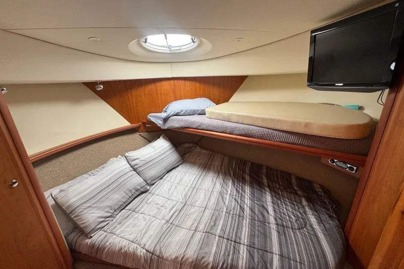 Slide: The Image of 2003 Silverton 39 Motor Yacht cabin with cozy bedding and wall-mounted TV. - 38