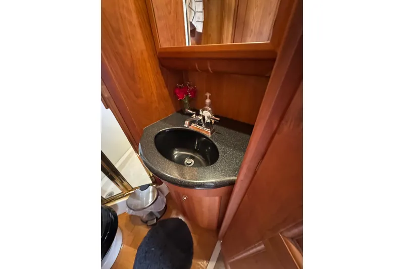 Slide: The Image of Bathroom sink area in 2003 Silverton 39 Motor Yacht, featuring wood cabinetry and modern fixtures. - 41