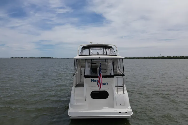 Slide: The Image of 2003 Silverton 39 Motor Yacht on calm water, rear view with American flag. - 6
