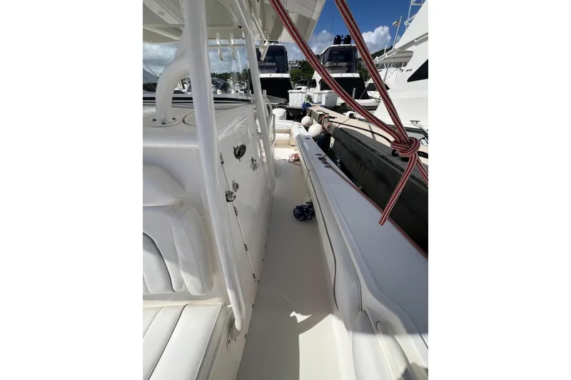 Slide: The Image of 2016 Regulator 34 Center Console boat interior with white seating and docked yachts. - 11