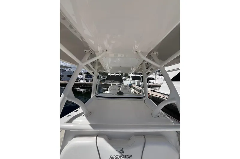 Slide: The Image of 2016 Regulator 34 Center Console boat, docked, showcasing sleek design and spacious layout. - 12