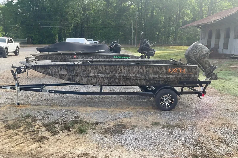 The Image of 2026 Excel Eclipse 1754 boat on trailer, camo design, parked outdoors. - 0