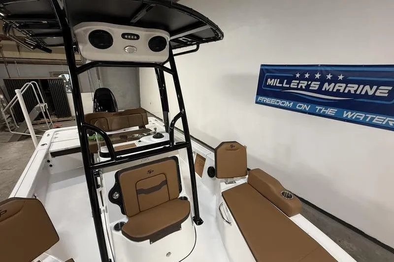 Slide: The Image of 2026 Sea Pro 210 Bay boat interior with brown seating at Miller's Marine showroom. - 16