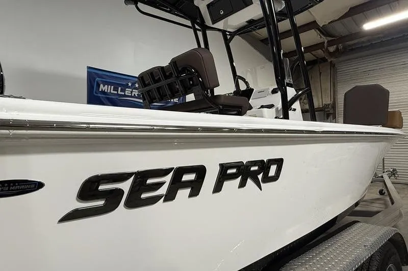 Slide: The Image of 2026 Sea Pro 210 Bay boat in a garage, side view with logo. - 2