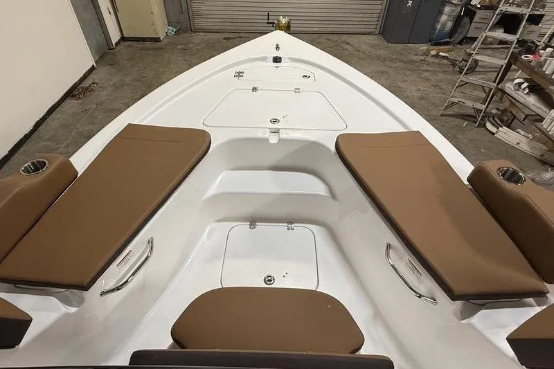 Slide: The Image of 2026 Sea Pro 210 Bay boat interior with brown cushioned seating and storage compartments. - 20