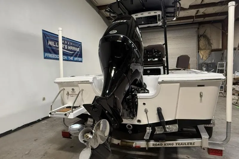 Slide: The Image of 2026 Sea Pro 210 Bay boat on trailer, featuring powerful outboard motor in a garage setting. - 5