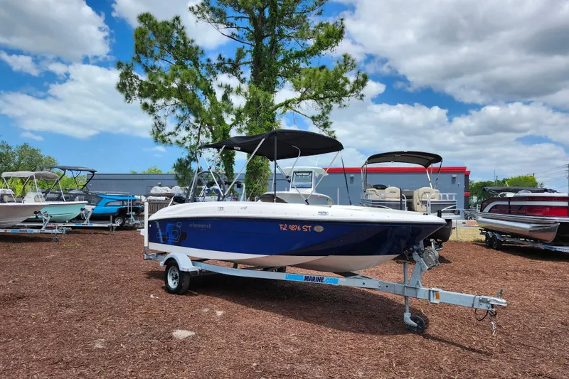 The Image of 2021 Bayliner Element E18 boat on trailer, parked outdoors under a cloudy sky. - 1