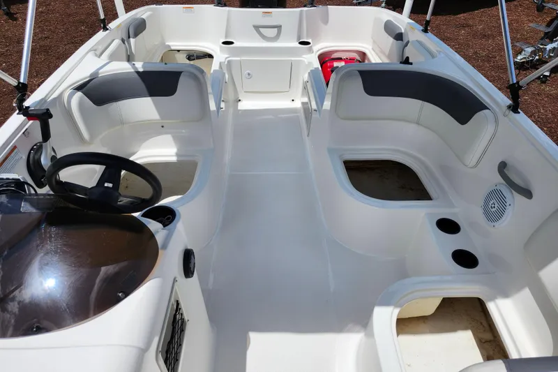 Slide: The Image of 2021 Bayliner Element E18 boat interior with seating, steering wheel, and cup holders. - 14