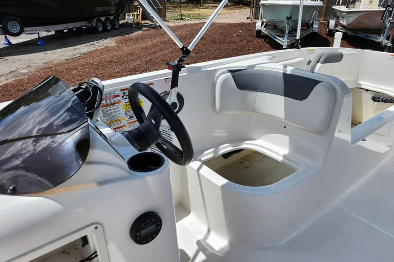Slide: The Image of 2021 Bayliner Element E18 boat interior with steering wheel and seating area. - 16