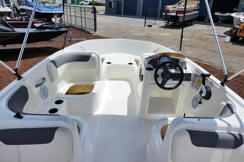 Slide: The Image of 2021 Bayliner Element E18 boat interior with seating and steering wheel. - 18