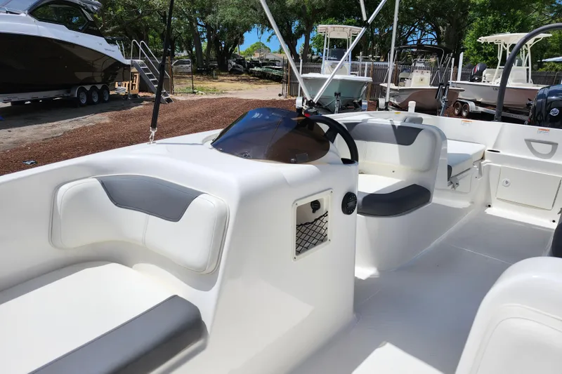 Slide: The Image of 2021 Bayliner Element E18 boat interior with seating and steering wheel. - 23