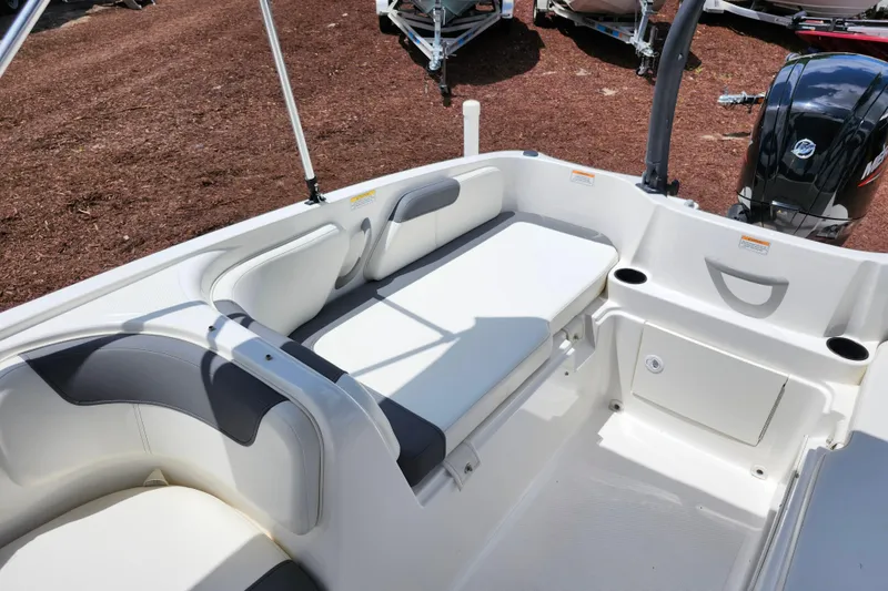 Slide: The Image of 2021 Bayliner Element E18 boat interior with white seating and storage compartments. - 25