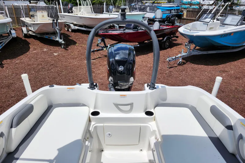 Slide: The Image of 2021 Bayliner Element E18 boat interior with seating and motor, surrounded by other boats. - 28