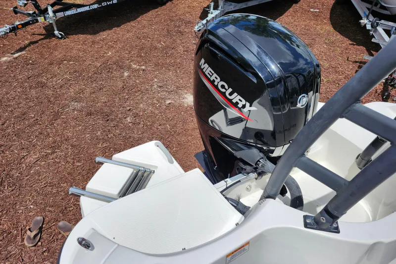 Slide: The Image of 2021 Bayliner Element E18 with Mercury outboard motor, parked on mulch ground. - 33
