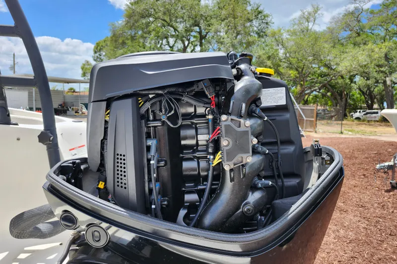 Slide: The Image of 2021 Bayliner Element E18 outboard motor, detailed view, outdoors with trees in background. - 44