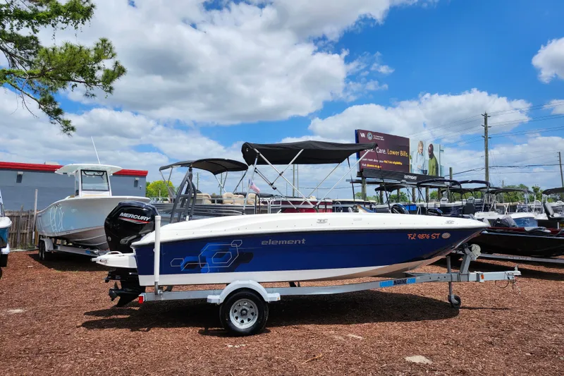 Slide: The Image of 2021 Bayliner Element E18 boat on trailer, displayed outdoors under a blue sky. - 8