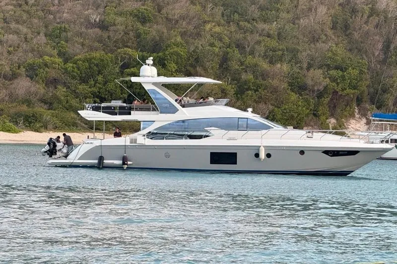 The Image of 2017 Azimut 66 yacht anchored near lush shoreline. - 0