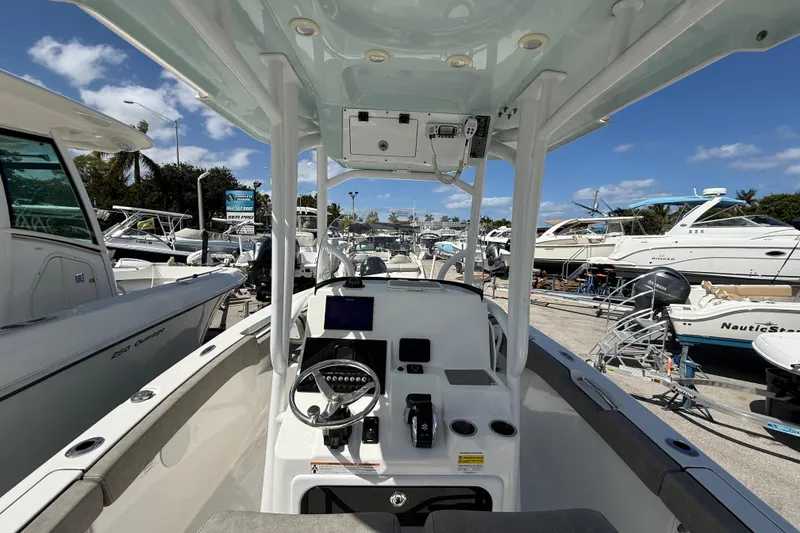 Slide: The Image of 2023 Sea Pro 219 Center Console boat interior at a marina, showcasing helm and controls. - 10