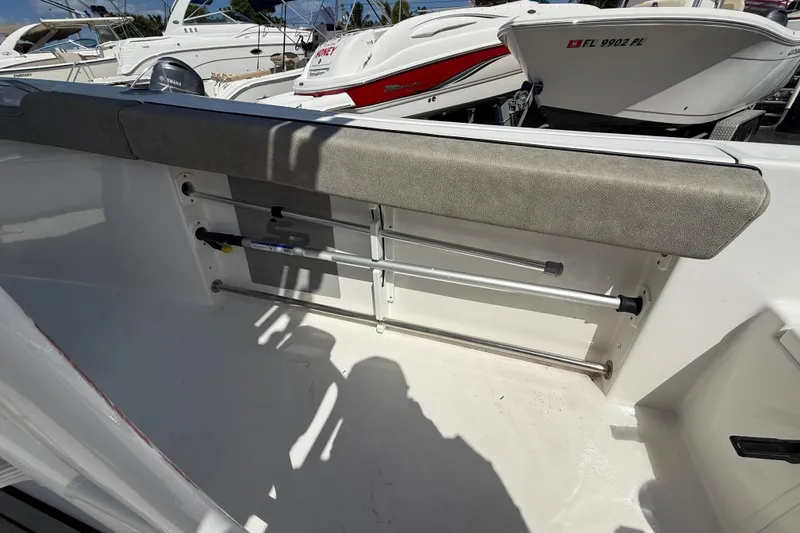 Slide: The Image of 2023 Sea Pro 219 Center Console boat interior with rod holders and cushioned seating. - 11