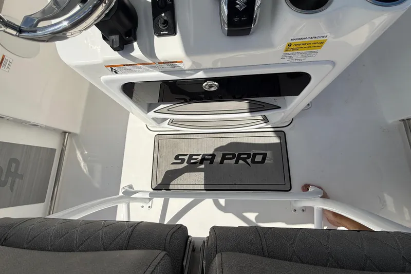 Slide: The Image of 2023 Sea Pro 219 Center Console boat interior with steering wheel and branded mat. - 17