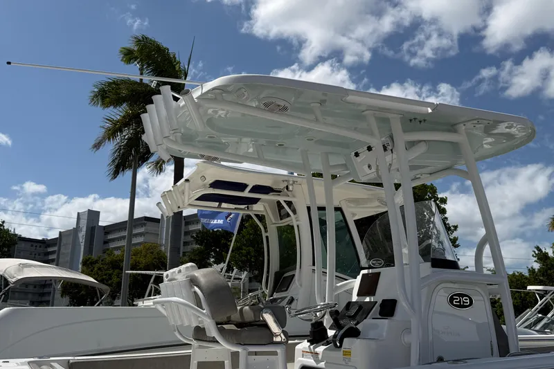Slide: The Image of 2023 Sea Pro 219 Center Console boat with T-top under a blue sky. - 2