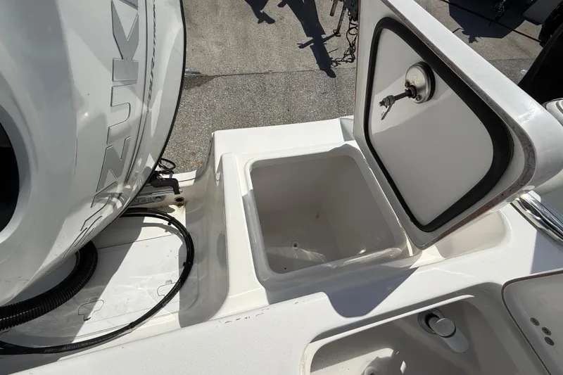 Slide: The Image of 2023 Sea Pro 219 Center Console boat with open storage compartment and visible engine. - 9