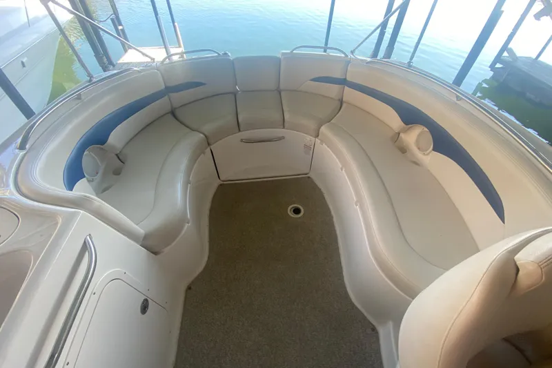 Slide: The Image of 2003 Chaparral Sunesta 263 boat interior with curved seating and blue accents. - 14