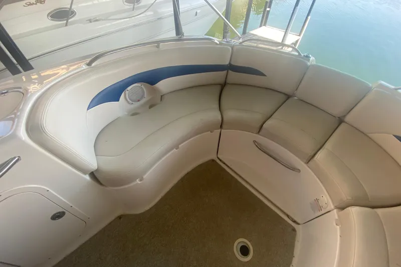 Slide: The Image of 2003 Chaparral Sunesta 263 boat interior with curved seating and blue accents. - 16