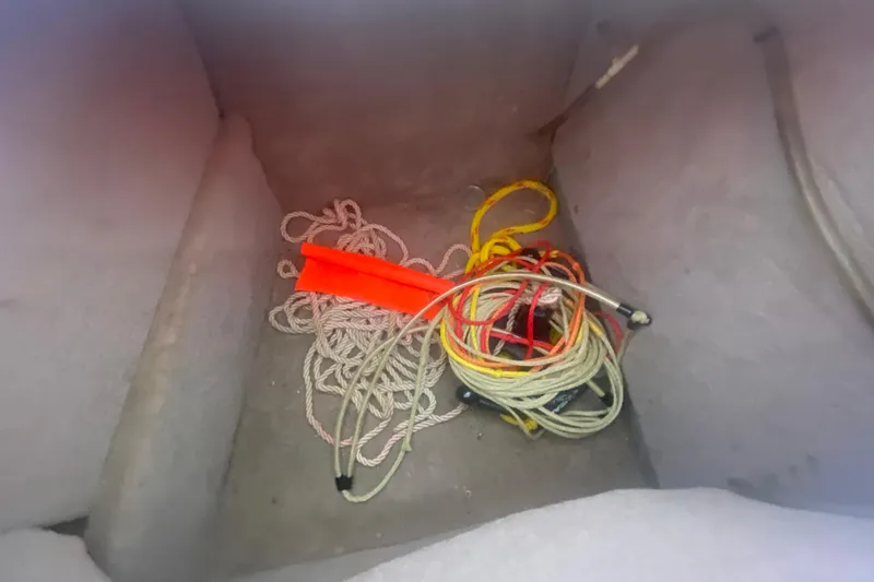 Slide: The Image of Storage compartment of 2003 Chaparral Sunesta 263 with ropes and an orange float. - 17