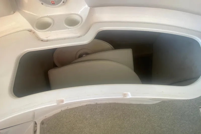 Slide: The Image of Storage compartment in a 2003 Chaparral Sunesta 263 boat, featuring cup holders and speaker. - 18