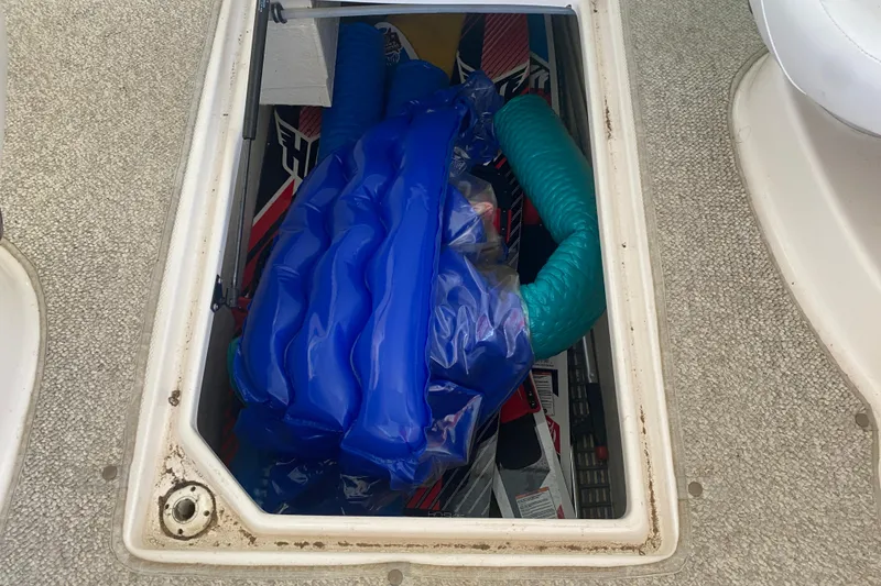 Slide: The Image of Storage compartment of a 2003 Chaparral Sunesta 263 boat with inflatables and gear. - 20