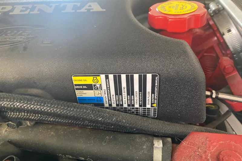 Slide: The Image of Engine compartment of a 2003 Chaparral Sunesta 263 boat, showing oil and maintenance labels. - 22