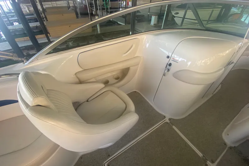 Slide: The Image of 2003 Chaparral Sunesta 263 boat interior with white seating and carpeted flooring. - 23