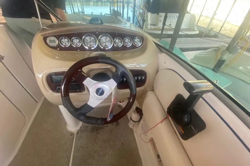 Slide: The Image of 2003 Chaparral Sunesta 263 boat dashboard with steering wheel and control panel. - 26